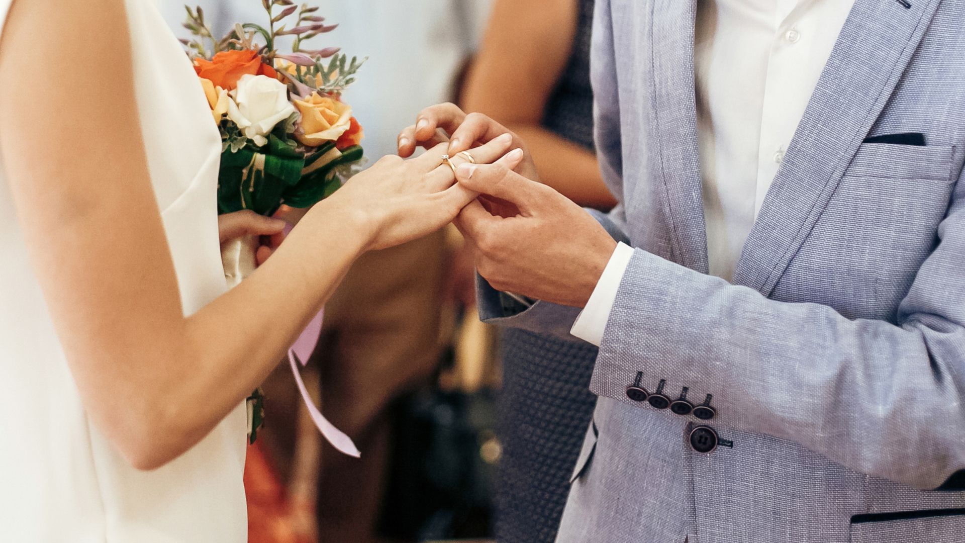 Ślub ekumeniczny – pan młody zakłada pannie młodej obrączkę na palec w trakcie ceremonii.